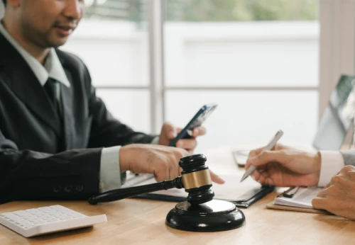 Attorney discussing a criminal defense case with a client beside a judge's gavel